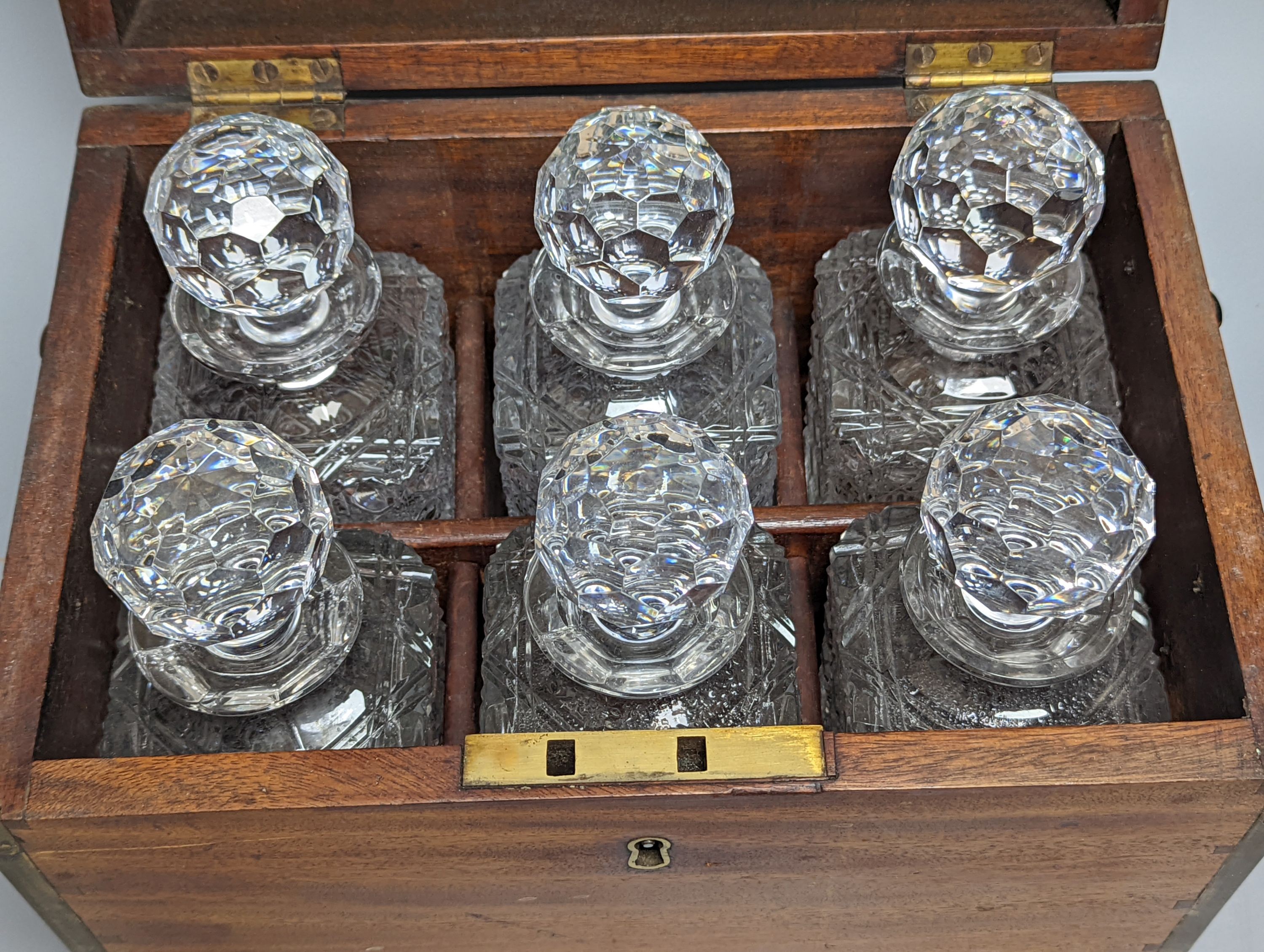 A brass bound mahogany six bottle decanter box, containing 6 cut glass decanters